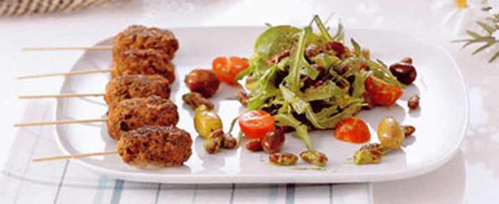 Cevapcici serveret med bønnesalat vendt i salsa verte
