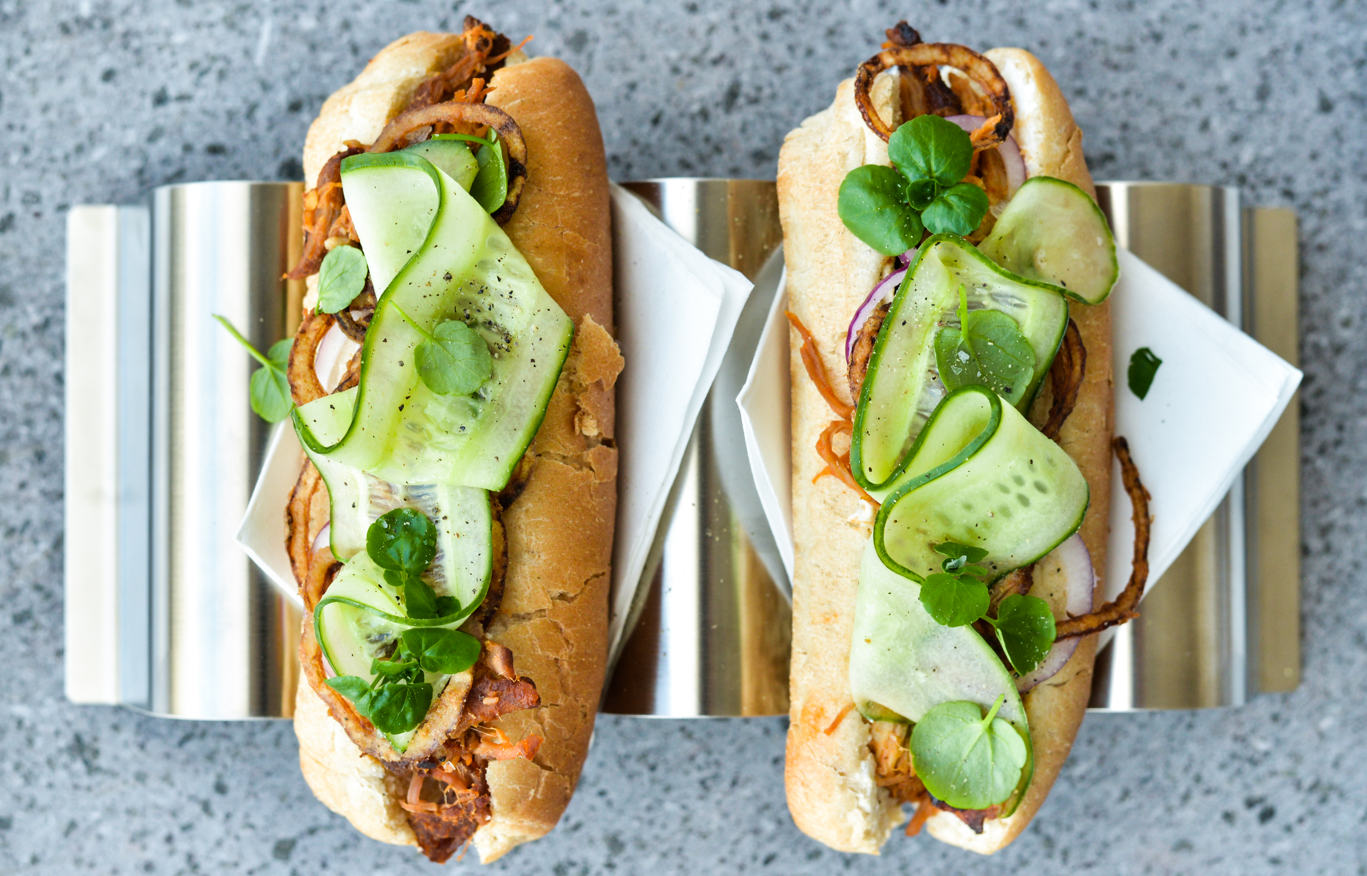 Pulled pork-hotdogs med hjemmestegte løg og syltede agurkestrimler
