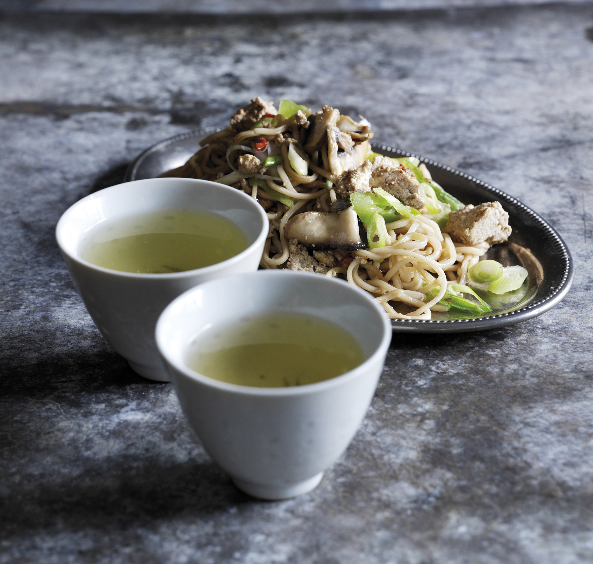 En portion stegte grøntsager og tofu med nudler