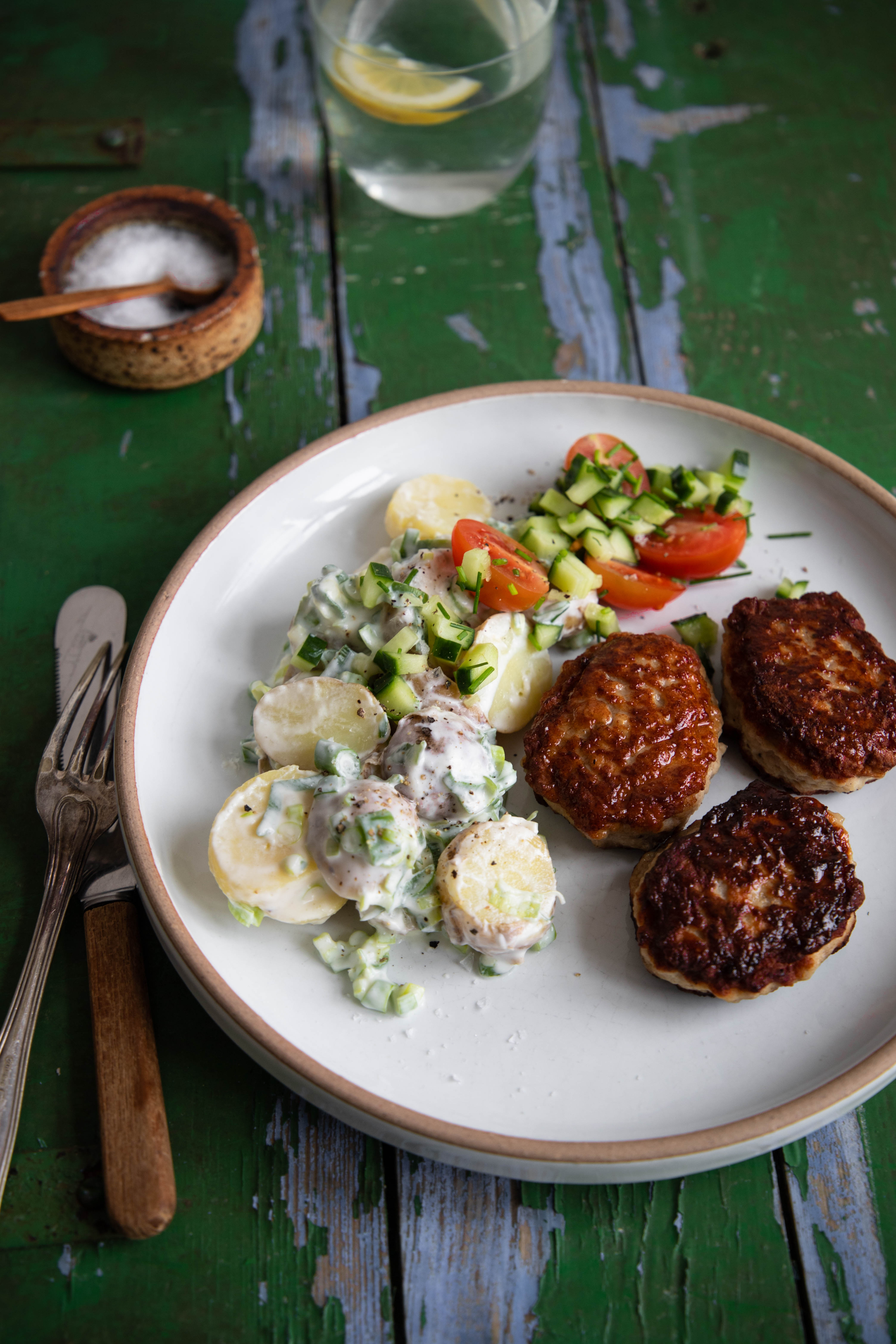 Frikadeller med kartoffelsalat, tomater, agurk, forårsløg og purløg