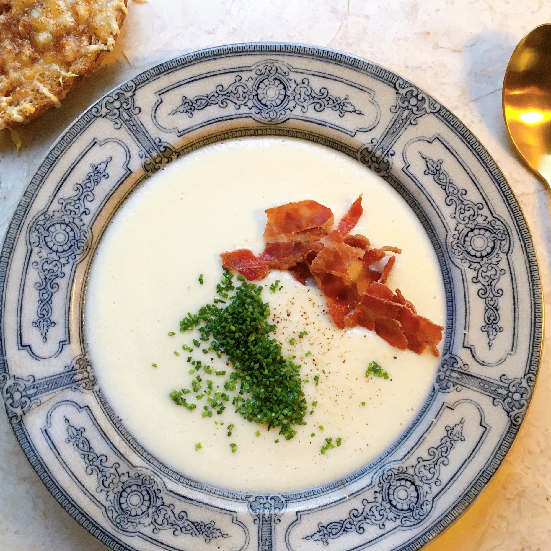 Cremet blomkålssuppe med bacon, purløg og brød