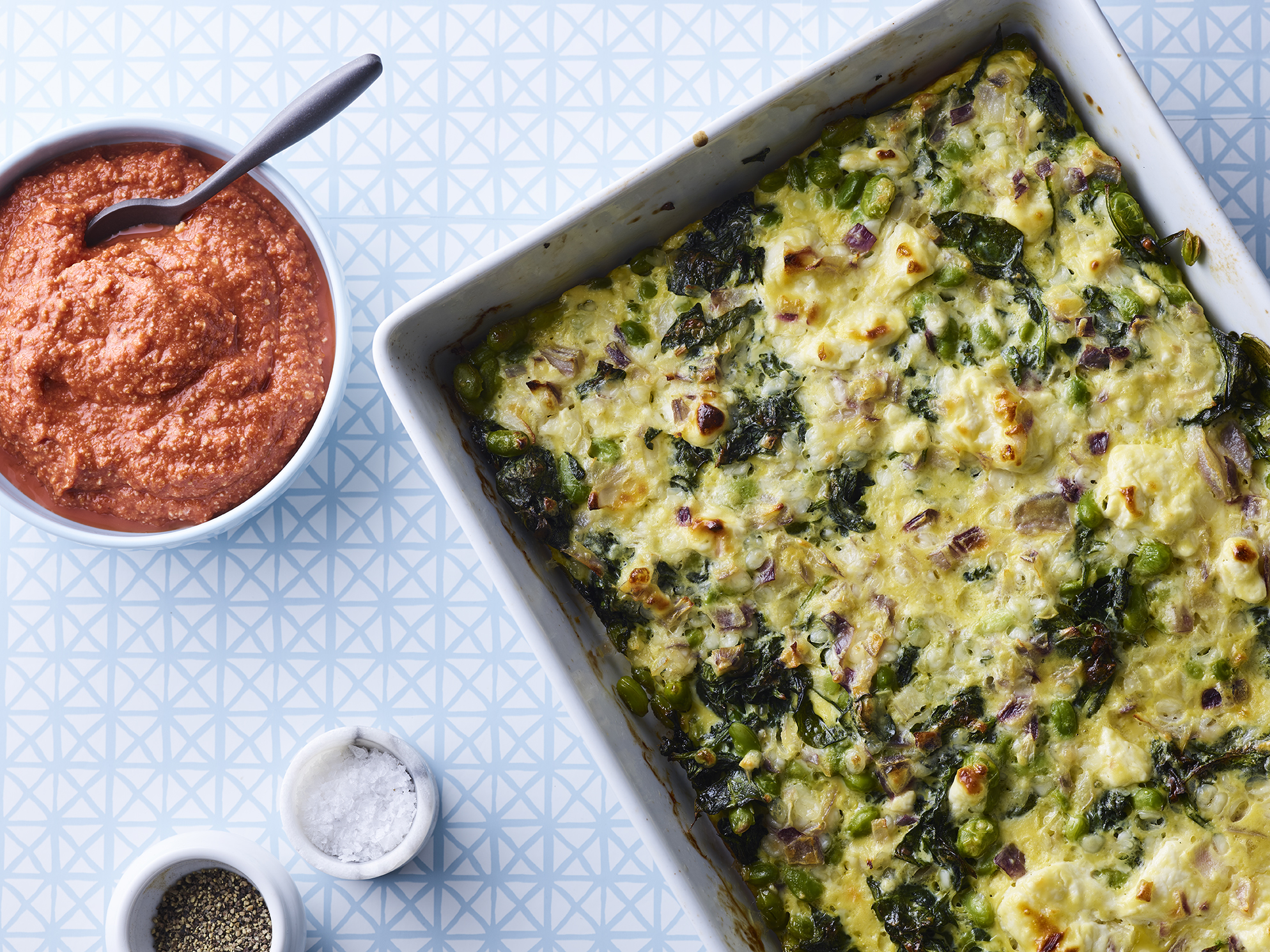 Gratin med spinat og edamame serveret med tomatsauce