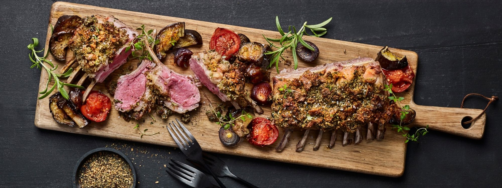Lammekrone med urtecrust, bagte tomater, aubergine og rødløg