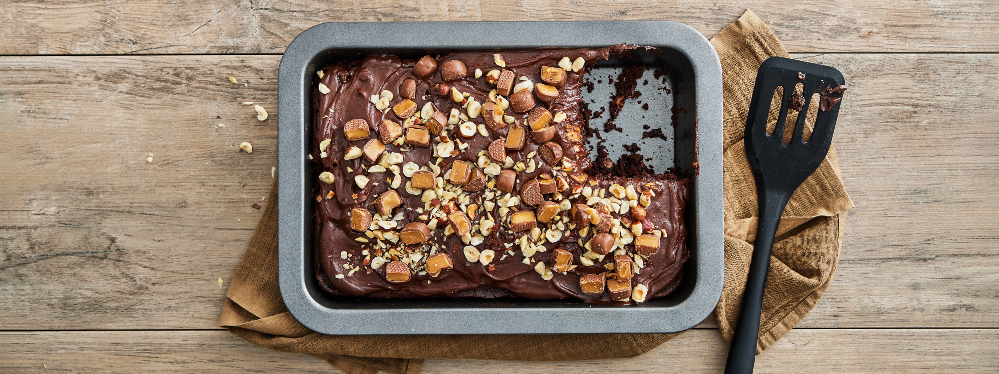 Svampet chokoladekage med topping af ganache, nødder og dumlekarameller