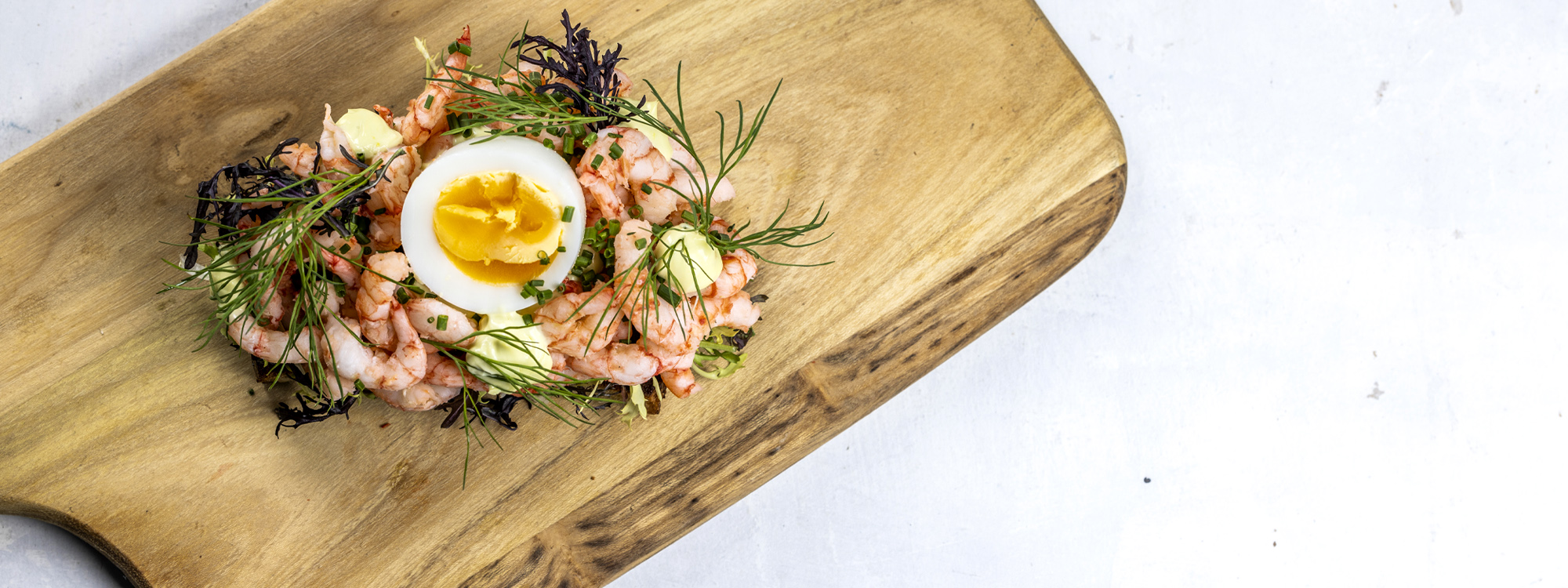 Smørrebrød med æg og rejer og urter