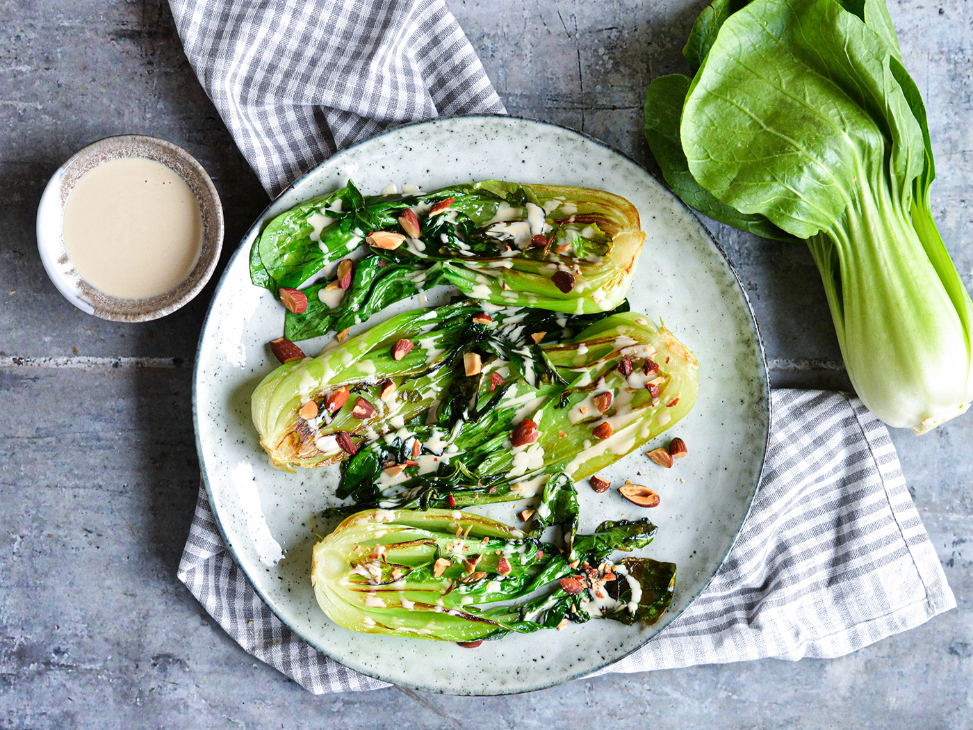 Stegt pak choi med tahindressing og saltmandler