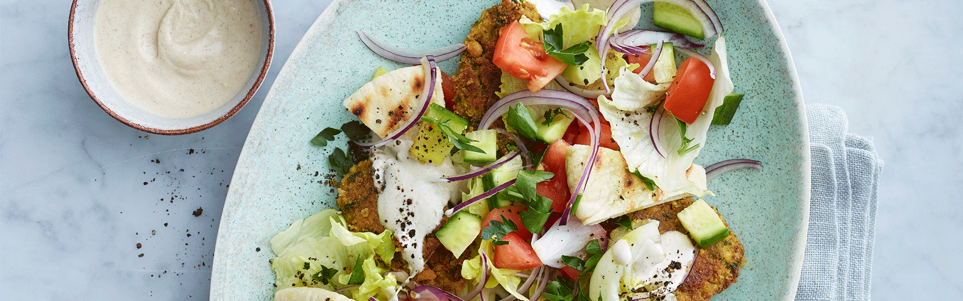 Falafelsalat med tahin-dressing, tomat, løg og ristet pitabrød