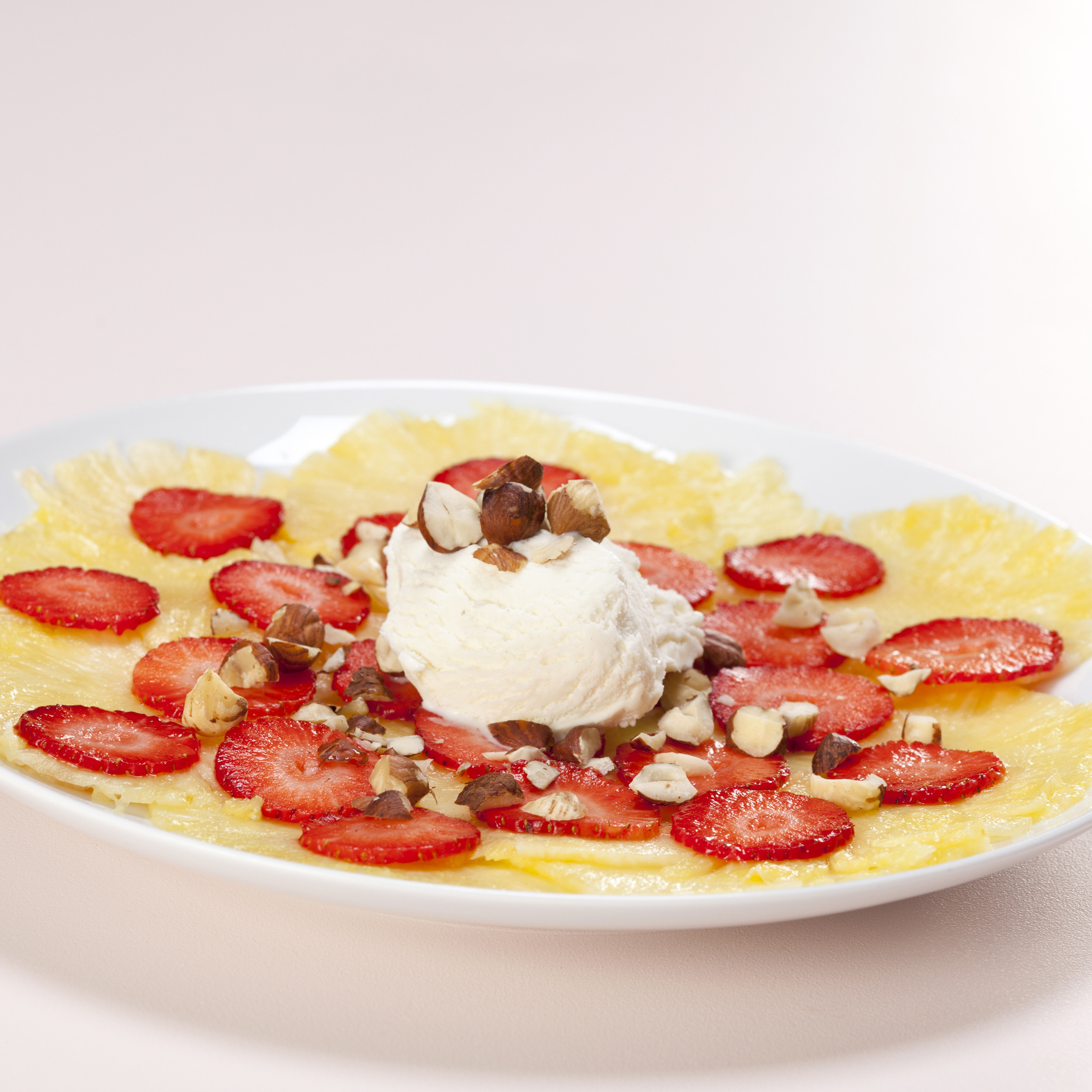 Ananas- og jordbærcarpaccio med vaniljeis og hasselnødder
