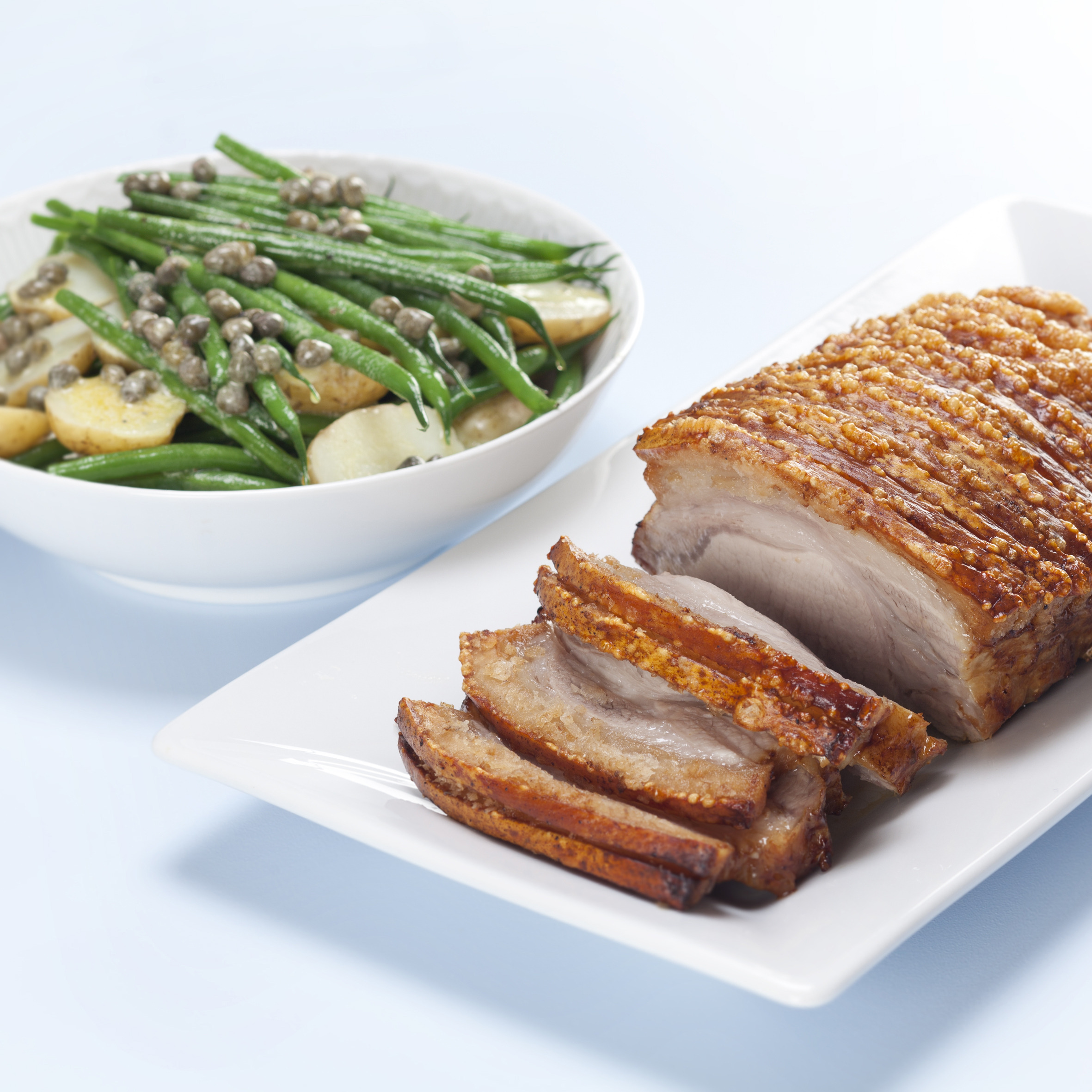 Flæskesteg med marinerede kartofler med bønner og kapers