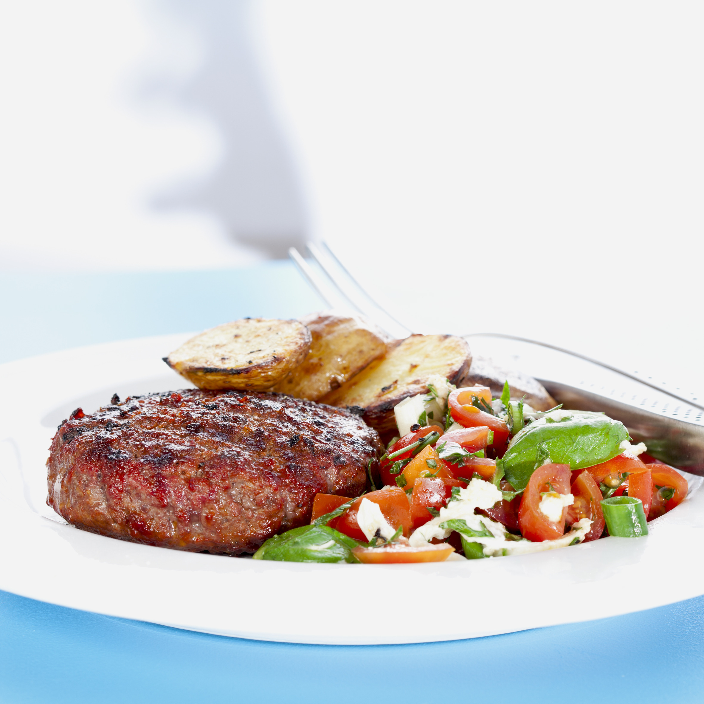 Grill-hakkebøf med tomatsalat og grillede kartofler