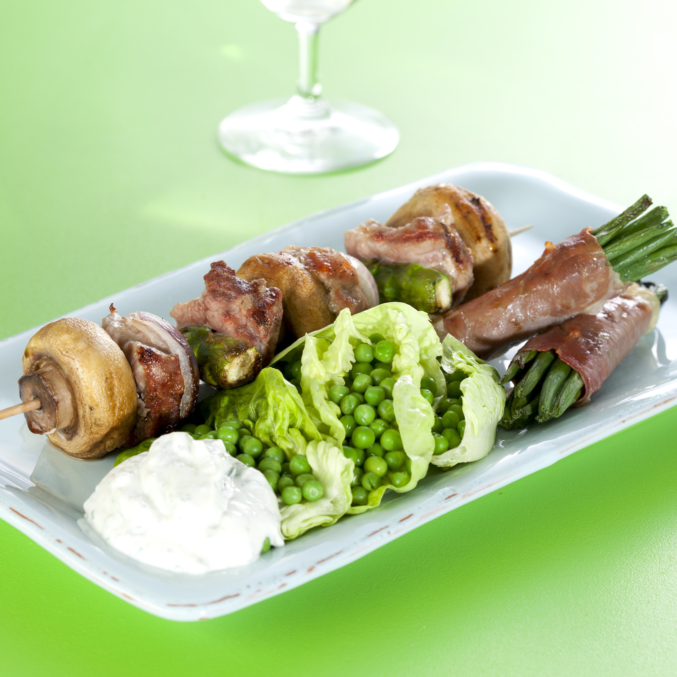 Grill-spyd med svinemørbrad, svampe og asparges med bønner i parmasvøb og ærter