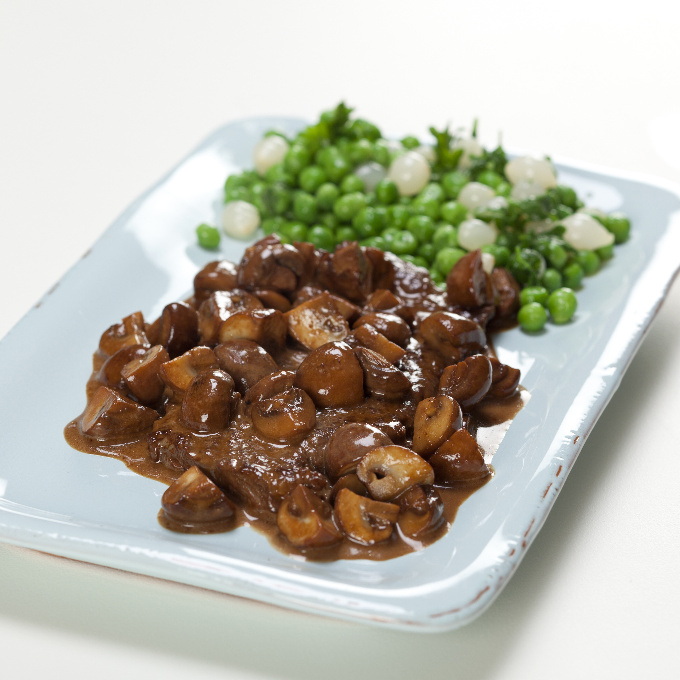 Kalveschnitzler i svampesauce med franske ærter