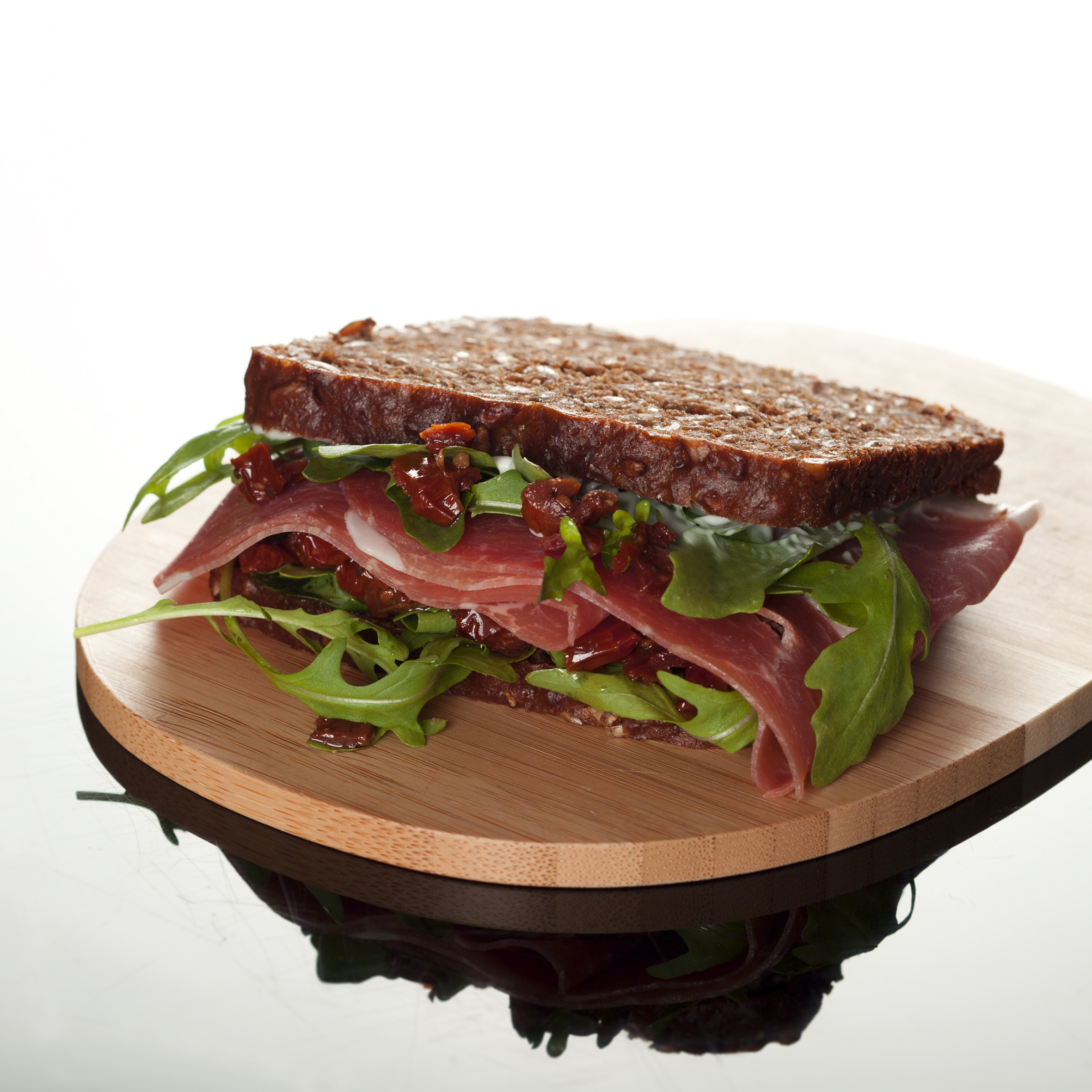 Rugbrødssandwich med lufttørret skinke, tomater og rucola