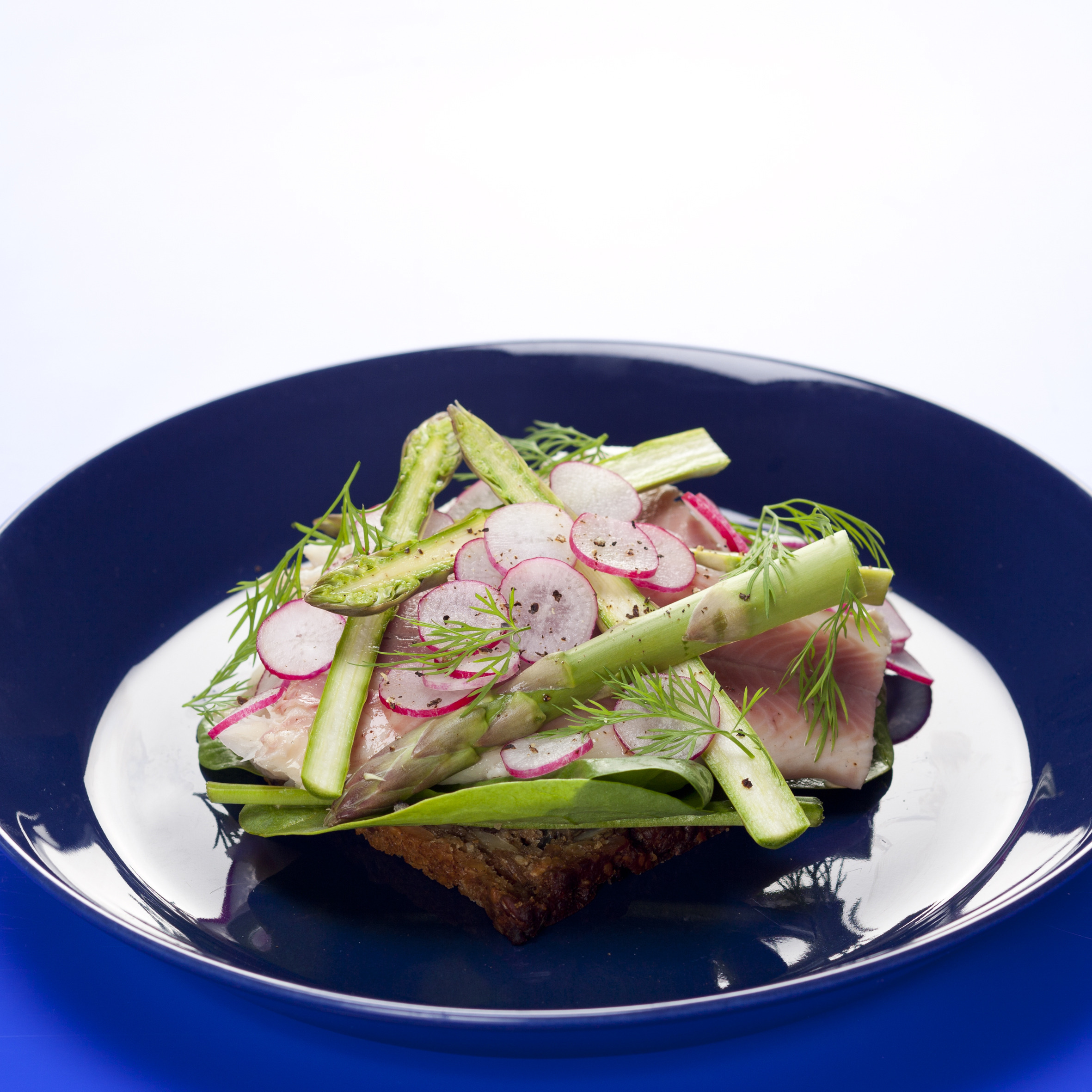 Smørrebrød med røget ørred, spinat, radiser, asparges og dild