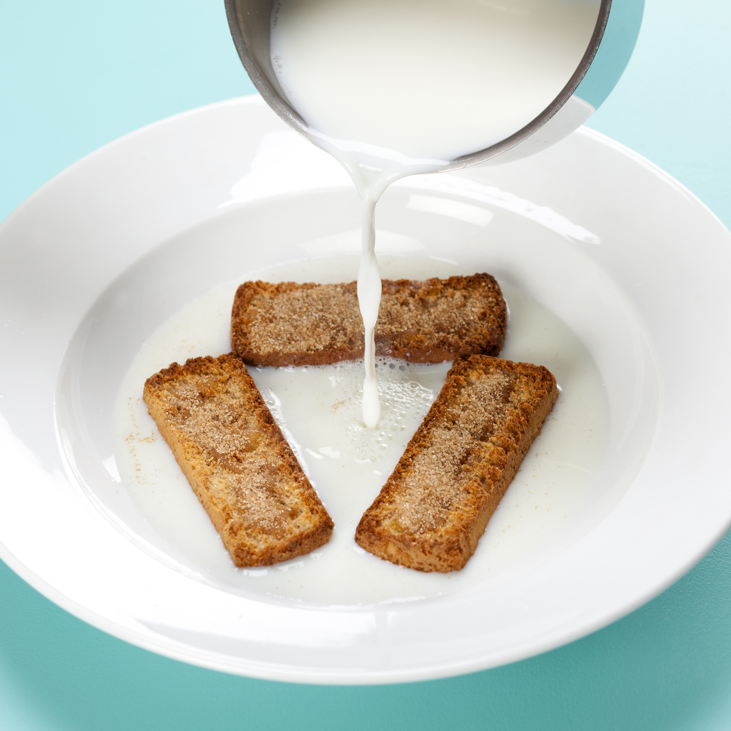 Varm mælk med tvebakker, honning og kanelsukker