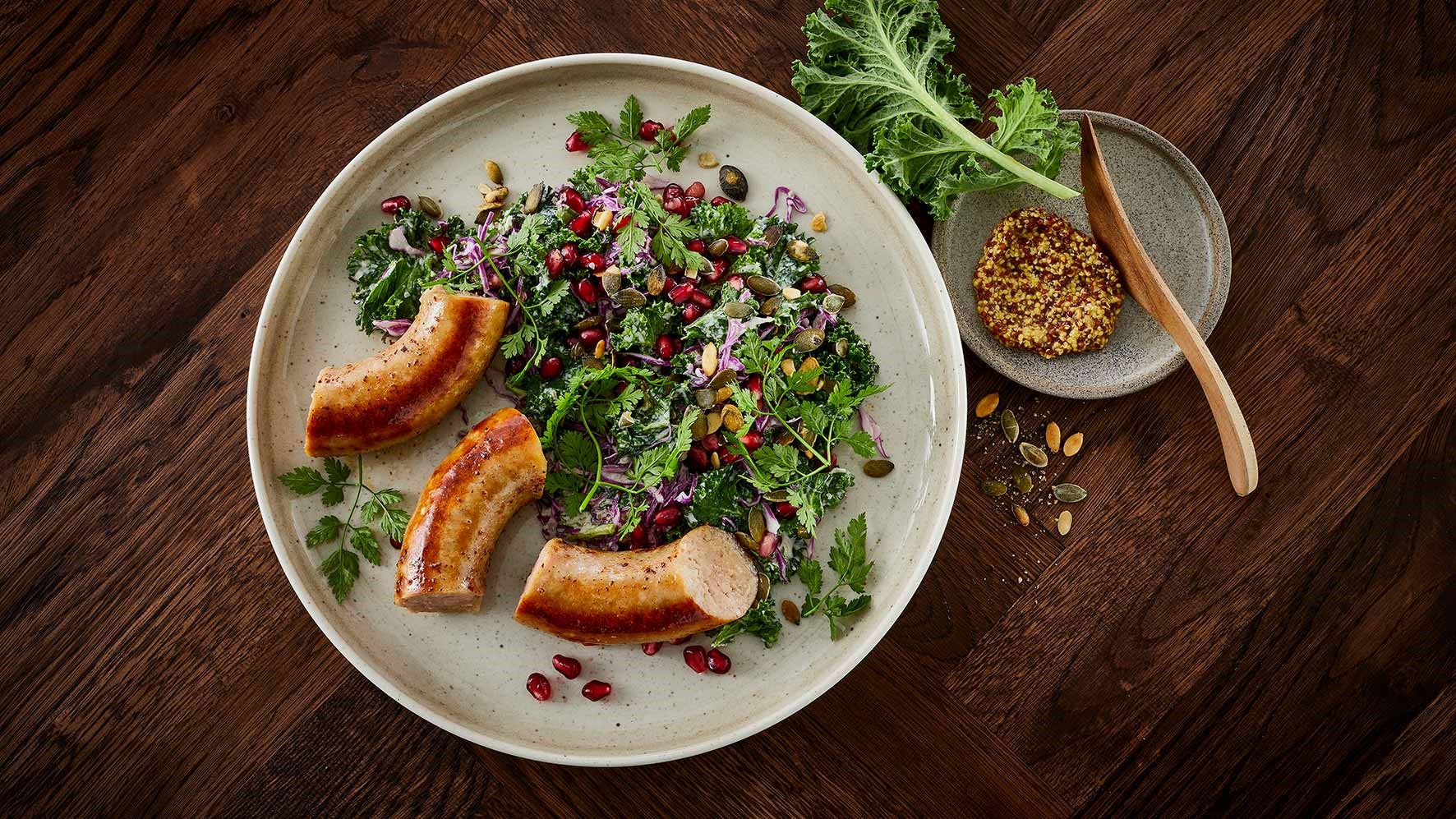 Stegt medister med cremet salat af grønkål, rødkål og granatæblekerner