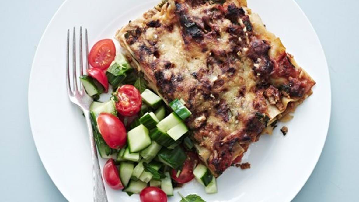 Lasagne med spinat og svinekød. Hertil frisk salat af tomat og agurk