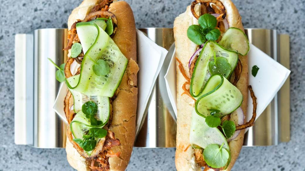 Pulled pork-hotdogs med hjemmestegte løg og syltede agurkestrimler